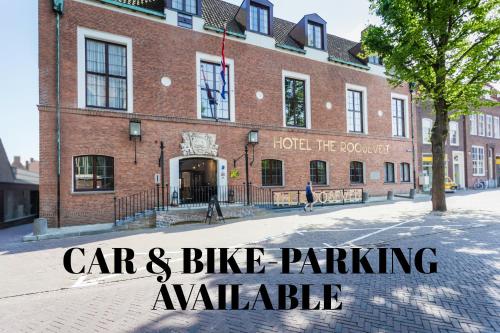 a red brick building with the text car and bike parking available at Boutique Hotel The Roosevelt in Middelburg