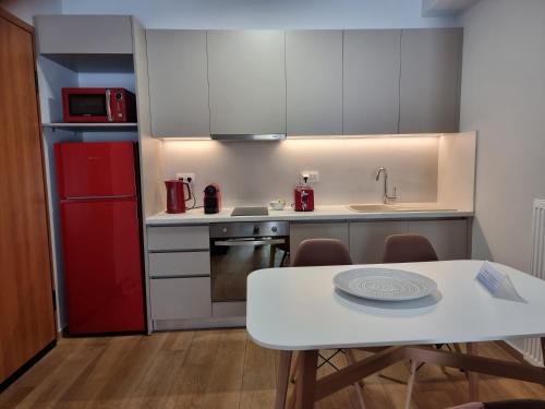 a kitchen with a white table and a red refrigerator at Athens' Secret Jewel in Athens