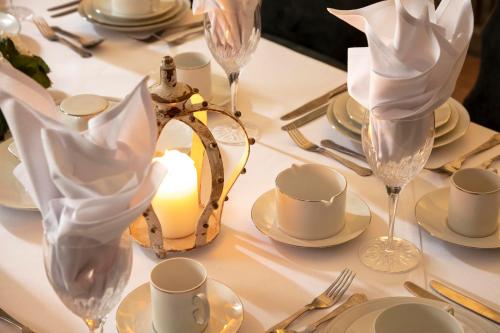 a table with a candle and plates and glasses on it at Manor House Hotel in Bishop Auckland
