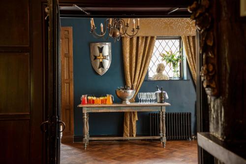 a blue room with a table and a window at Manor House Hotel in Bishop Auckland