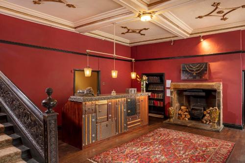 a living room with red walls and a fireplace at Manor House Hotel in Bishop Auckland