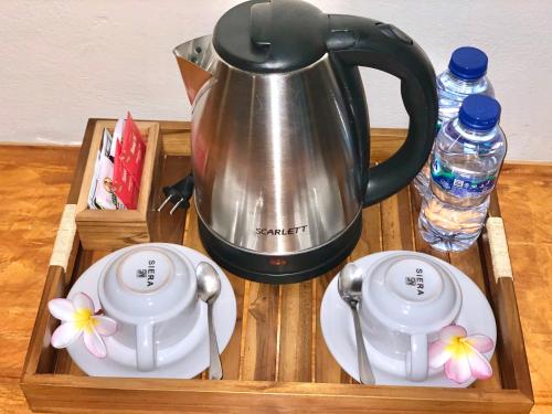 ein Tablett mit einem Wasserkocher und zwei Tassen auf einem Tisch in der Unterkunft The Dulu Penida in Nusa Penida
