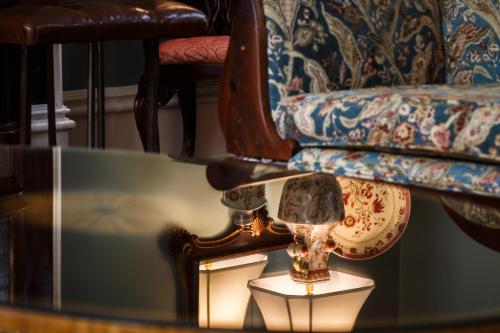 a glass table with a lamp and a chair at Eliza Thompson House, Historic Inns of Savannah Collection in Savannah