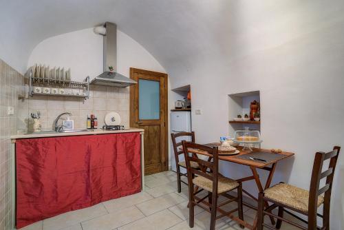 cocina con fregadero y mesa con sillas en Il Trulletto, en Montalbano
