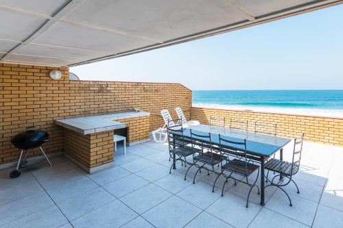 a patio with a table and chairs and the ocean at Alomsee 3 in Ballito