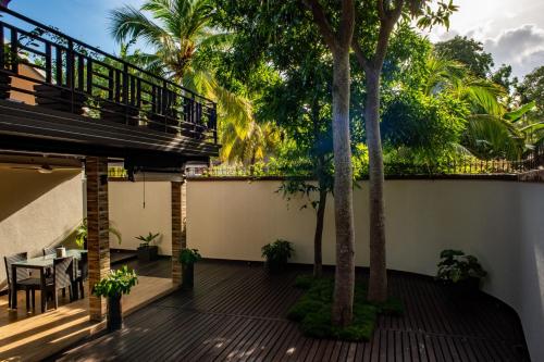 Fuvahmulah的住宿－Isle Royal Inn，阳台配有桌椅和棕榈树。