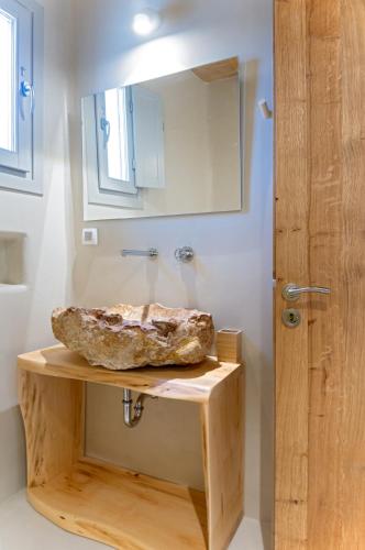 a bathroom with a stone sink and a mirror at Mystic Villas Koufonisi in Koufonisia