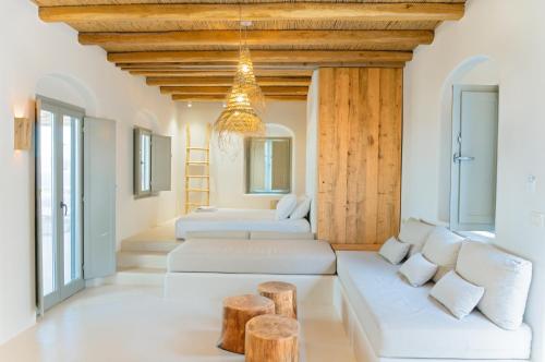 una sala de estar con muebles blancos y techos de madera. en Mystic Villas Koufonisi, en Koufonisia