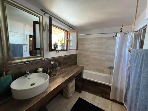 a bathroom with a sink and a mirror and a tub at Horizon Art Villa in Rodia