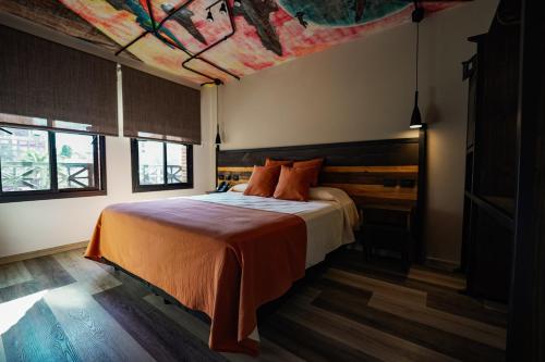 Schlafzimmer mit einem Bett und Deckengemälde in der Unterkunft Terra Firma Hotel Boutique in Villa Carlos Paz