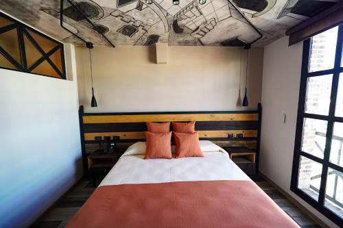 a bedroom with a bed with two orange pillows at Terra Firma Hotel Boutique in Villa Carlos Paz