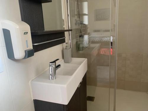 a bathroom with a white sink and a shower at Nice apartment close to park Guell1 in Barcelona