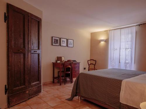 um quarto com uma cama, uma secretária e uma janela em Alloggio del Vicolo - Le Vecchie Vasche em Coppito
