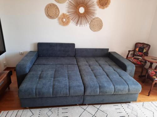 - un canapé bleu dans le salon dans l'établissement Biser Dunava -- Pearl of Danube Apartment, à Smederevo