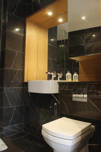 a bathroom with a toilet and a sink and a mirror at Luxury Canary Wharf 2 Bed Apartment With Panoramic Views in London