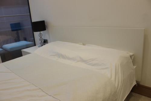 a white bed in a bedroom with a window at Luxury Canary Wharf 2 Bed Apartment With Panoramic Views in London