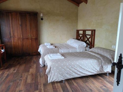 two beds in a room with wooden floors at Apartamento Láncara in Lugo