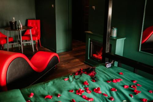 トルンにあるMake Love Apartment Premiumのベッドルーム1室(ベッド1台、暖炉、赤い椅子付)