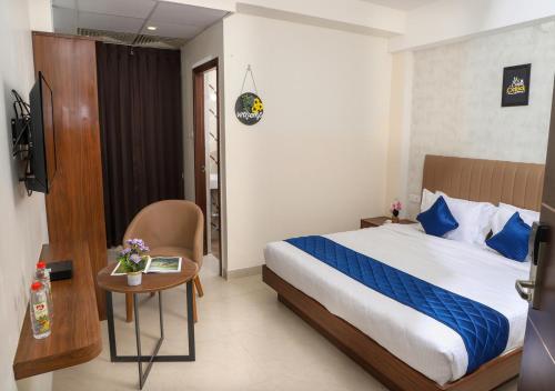 a hotel room with a bed and a table and a desk at Admira Residency in Coimbatore