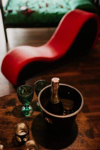 トルンにあるMake Love Apartment Premiumのワイン1本(テーブル、グラス、赤い椅子付)