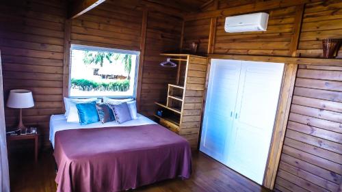 a bedroom with a bed in a wooden cabin at White Wind Resort in Itarema