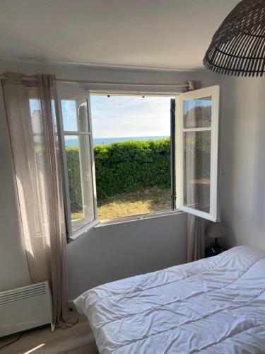 Schlafzimmer mit einem Bett und einem Fenster mit Aussicht in der Unterkunft Maison de vacances en bordure de mer ! in Batz-sur-Mer