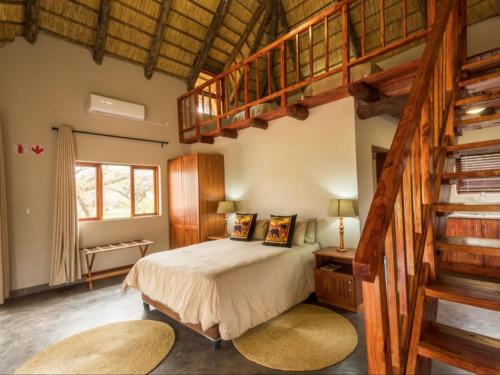 ein Schlafzimmer mit einem großen Bett und einer Treppe in der Unterkunft KaMsholo Bushveld Safaris 