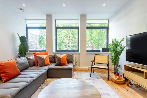 a living room with a couch and a flat screen tv at Stunning Modern Apartment in the Heart of Holborn in London