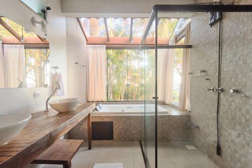 a bathroom with a tub and a sink and a shower at Sertão House - Fantástica residência em meio a natureza intocada no sul da ilha in Florianópolis