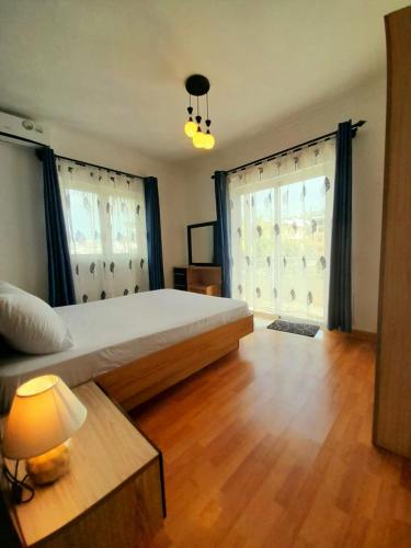 a bedroom with a large bed and two windows at Le Nid Flic en Flac in Flic-en-Flac