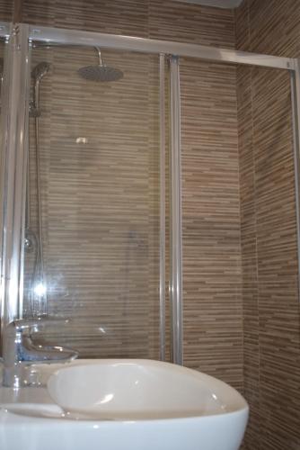 a bathroom with a shower and a white sink at Apartamento a pie de playa en As Sinas. in Villanueva de Arosa