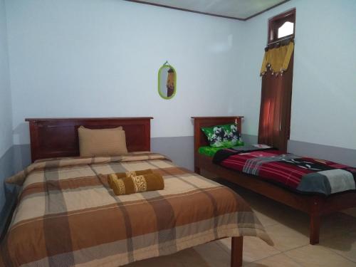 um quarto com 2 camas e uma janela em Arnolds Familly homestay em Bajawa