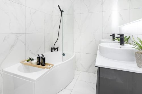 a white bathroom with a sink and a bath tub at Two Bedroom Apartment in Central London with Large Terrace in London
