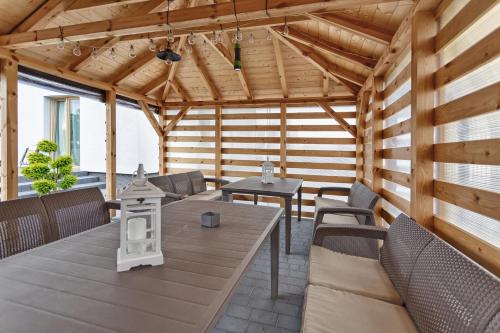 a wooden pavilion with a table and chairs at Willa La Calma in Łeba