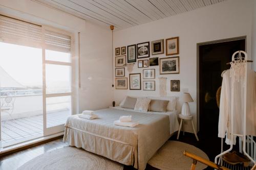 Un dormitorio blanco con una cama y una ventana grande. en "Villa Alba" authentic hospitality and sustainability in the heart on Langhe, en Alba