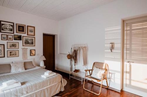 um quarto com uma cama, uma cadeira e uma janela em "Villa Alba" stay with the Somms em Alba