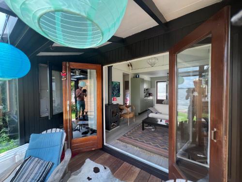 een woonkamer met zwarte muren en een glazen deur bij The Outpost Lakehouse- enjoy our house at Reeuwijkse Plassen - near Gouda in Reeuwijk