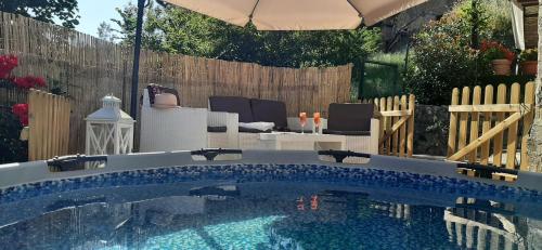 einen Pool im Hinterhof mit Sonnenschirm in der Unterkunft Beautiful 2-Bed House in Longoio Bagni Di Lucca in Longoio