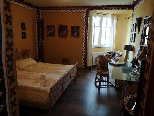 a bedroom with a bed and a desk and a chair at Hotel Goldflair am Rathaus in Korbach