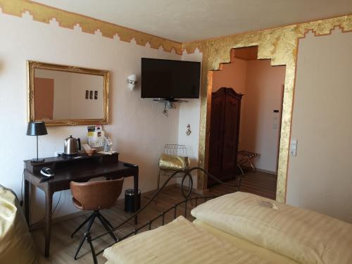 a room with a bed and a desk and a mirror at Hotel Goldflair am Rathaus in Korbach
