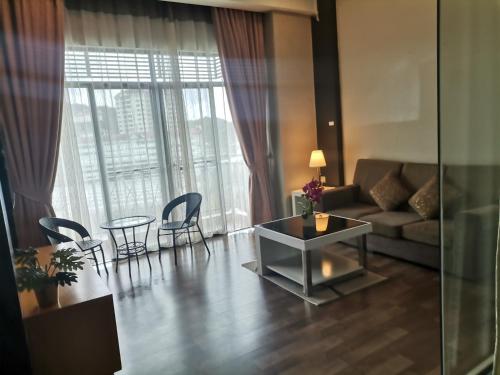 a living room with a couch and a table and chairs at Dzulstudio(Muslim) Nova Highland in Brinchang