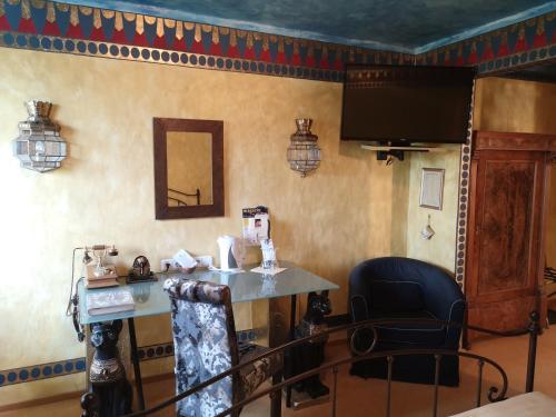 a room with a table and a chair and a television at Hotel Goldflair am Rathaus in Korbach