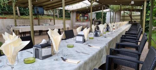 a long table with white table cloth and chairs at Hotel Dacor in Orăştie