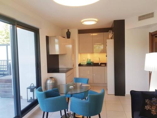 - une cuisine avec une table et des chaises bleues dans l'établissement Appartement d'exception - Vue panoramique sur lac, à Évian-les-Bains