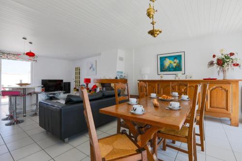 un salon avec une table et un canapé dans l'établissement Maison confortable à deux pas du village, à La Flotte