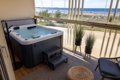 a hot tub in a room with a view of the beach at Marina Resort A5 in Kalajoki
