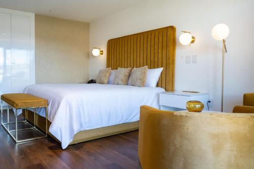 サカテカスにあるCasa Cuarzo Hotel Boutiqueの大きなベッドと椅子が備わるホテルルームです。
