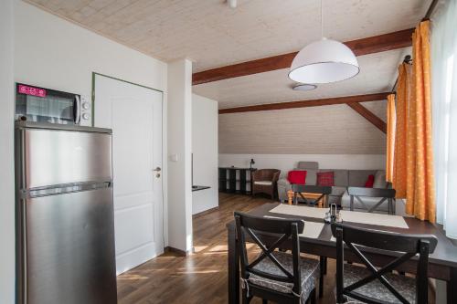 a kitchen and dining room with a table and a refrigerator at Pension Herman in Rudník