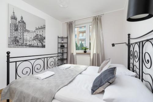 Un dormitorio con una cama en blanco y negro y una ventana en Pleasant Apartment with Terrace Cracow by Renters, en Cracovia