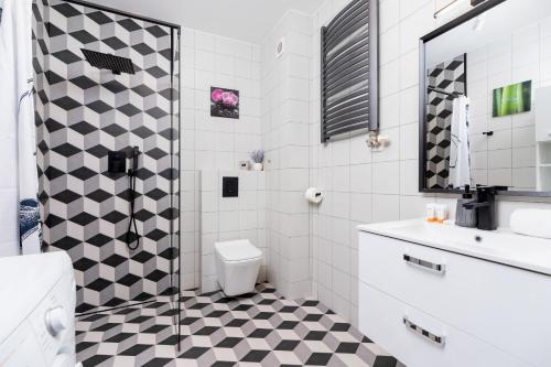 baño con suelo a cuadros en blanco y negro en Pleasant Apartment with Terrace Cracow by Renters, en Cracovia
